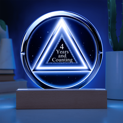 LED circle plaque with “4 Years and Counting” on wood base, bright blue glow