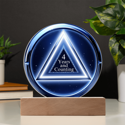 LED circle plaque with “4 Years and Counting” on wood base, blue glow