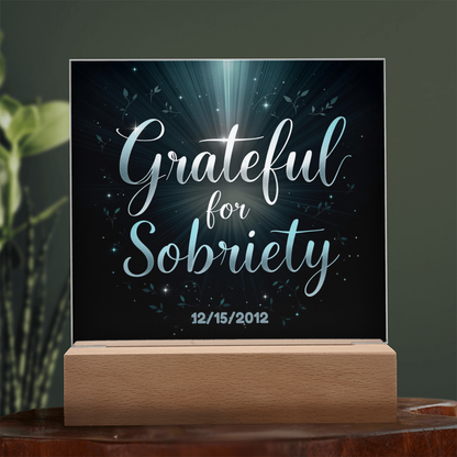 Close-up of LED acrylic sobriety sign with glowing light beams and custom date