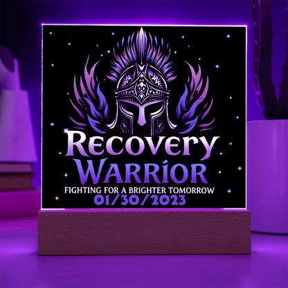 Square acrylic LED plaque on wood base, black front with teal graphics, purple-lit frame border