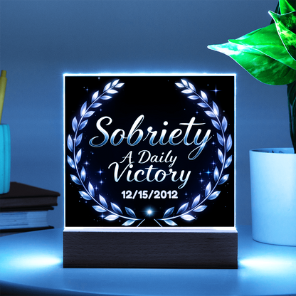 Square LED plaque on wood base with purple laurel wreath and “Sobriety A Daily Victory” text.