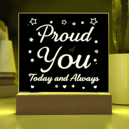 LED message plaque with yellow-green glow and glowing “Proud of You” on wooden base