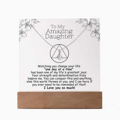 LED acrylic plaque with necklace and heart pendant on silver-toned chain, wood base