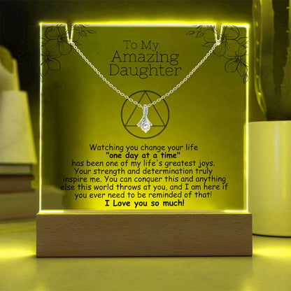 LED acrylic plaque with necklace and heart pendant on silver-toned chain, warm yellow light