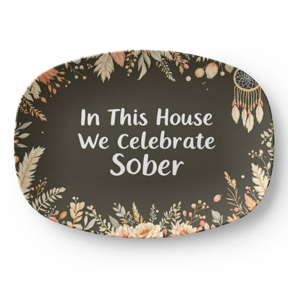 Dark green oval serving platter with floral border and 'In This House...' white text