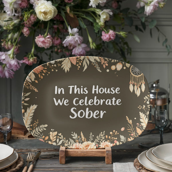 Dark green oval serving platter on stand with floral border and white 'We Celebrate Sober' text