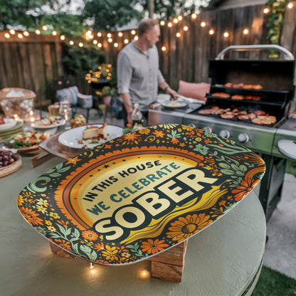 Decorative oval platter with “IN THIS HOUSE WE CELEBRATE SOBER” text and florals