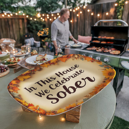 Oval serving platter tilted with autumn leaf border and text "In This House We Celebrate Sober"