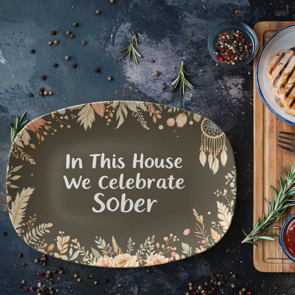Dark green oval serving platter with floral border and 'In This House...' white text