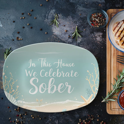 Seafoam oval serving platter reading “In This House We Celebrate Sober” with coastal plants