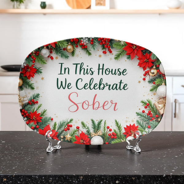 Oval holiday serving platter with poinsettia wreath border and 'In This House We Celebrate Sober' text