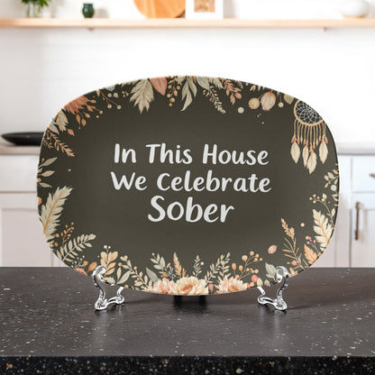 Dark green oval serving platter on stand with floral border and white 'Sober' text
