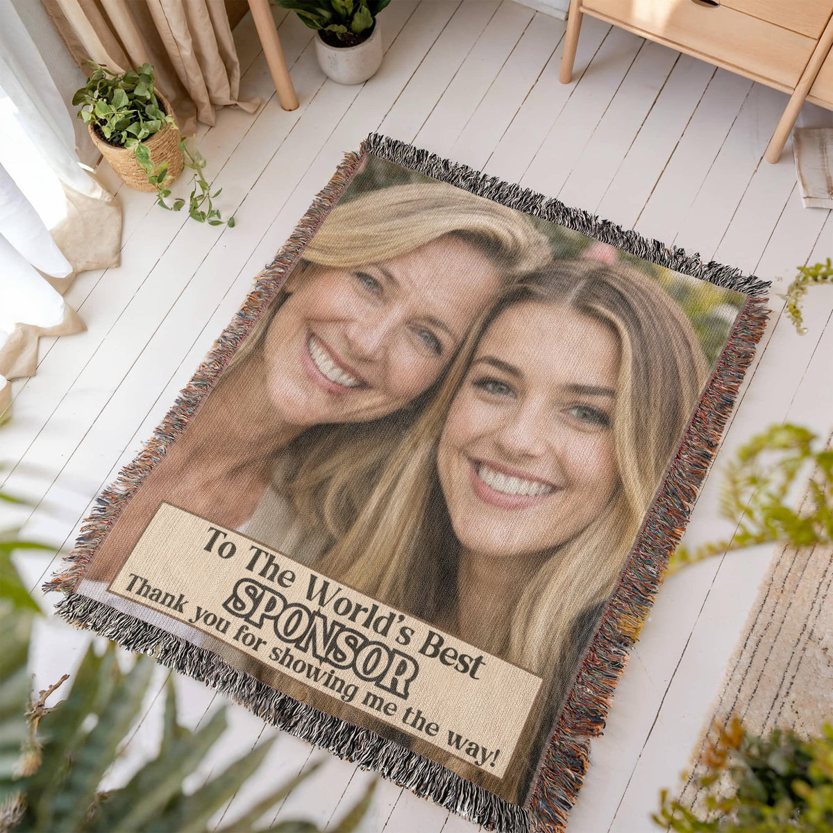 Fringed photo throw blanket laid flat, with two smiling women and sponsor thank-you message