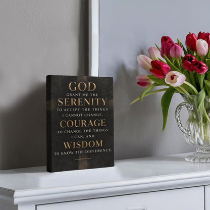 Black vertical canvas wall art with gold Serenity Prayer text, displayed on tabletop.