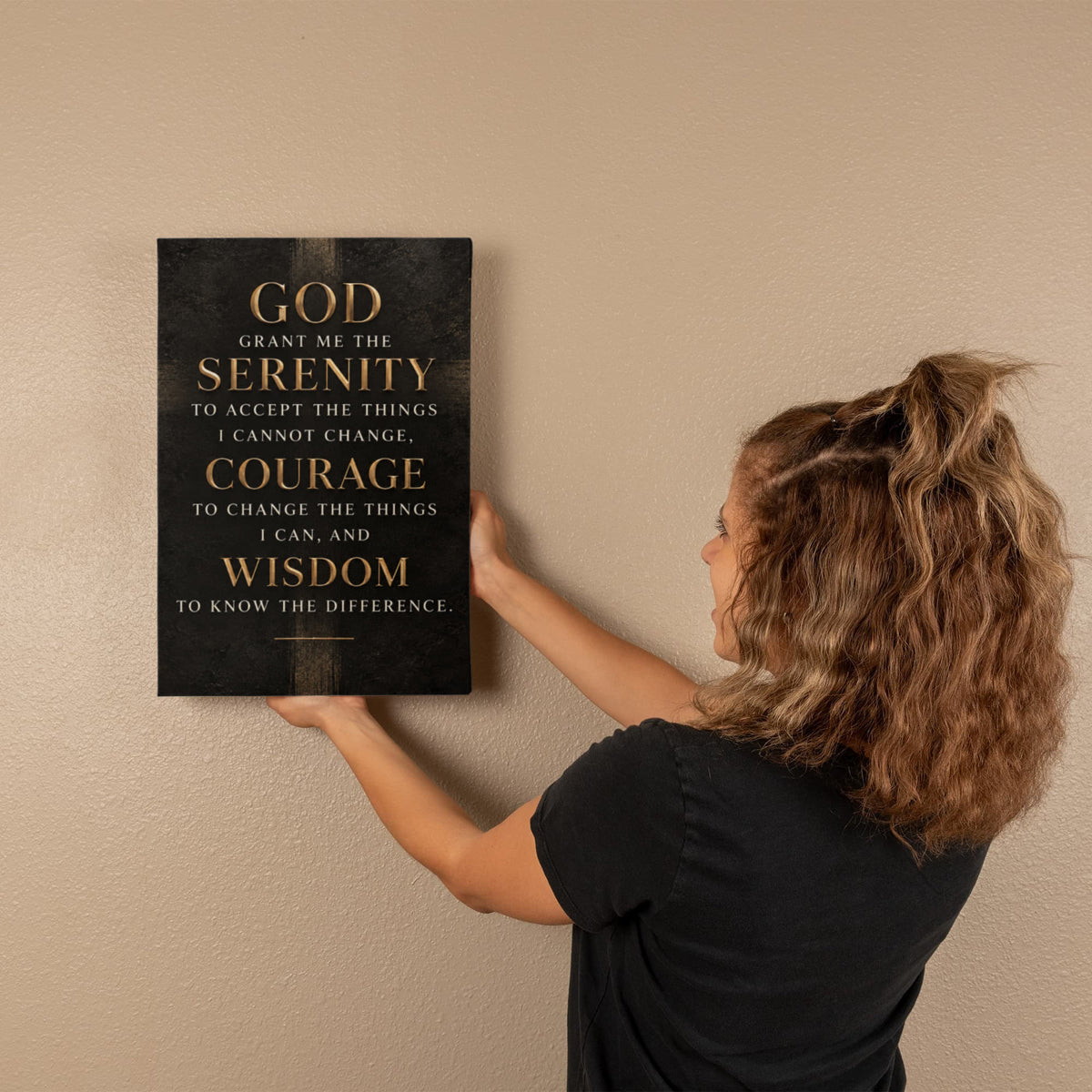Black vertical canvas wall art with gold Serenity Prayer text mounted on wall.
