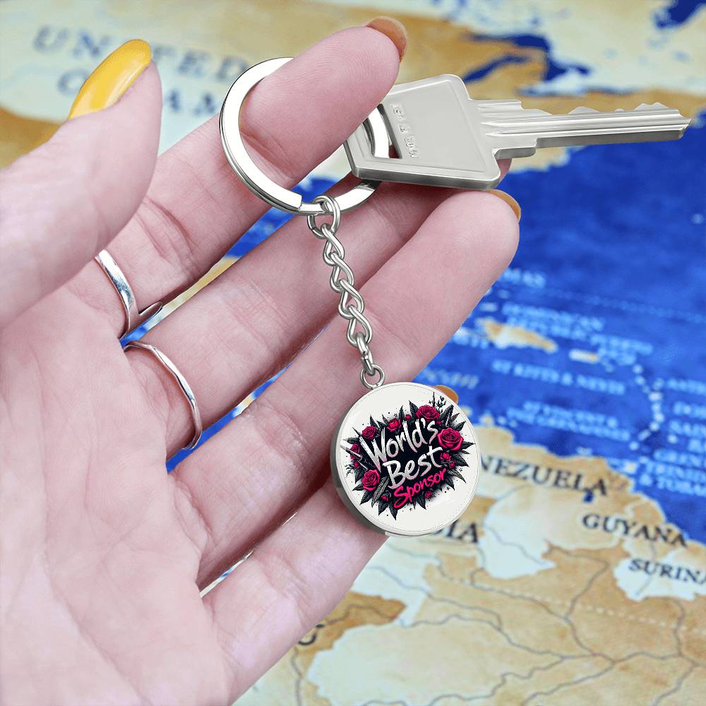 Round silver keychain charm with rose “World’s Best Sponsor” design held in hand