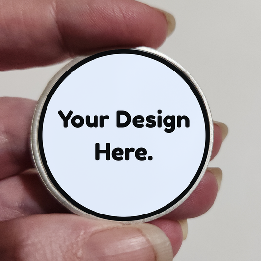 Round silver custom coin with placeholder text "Your Design Here."