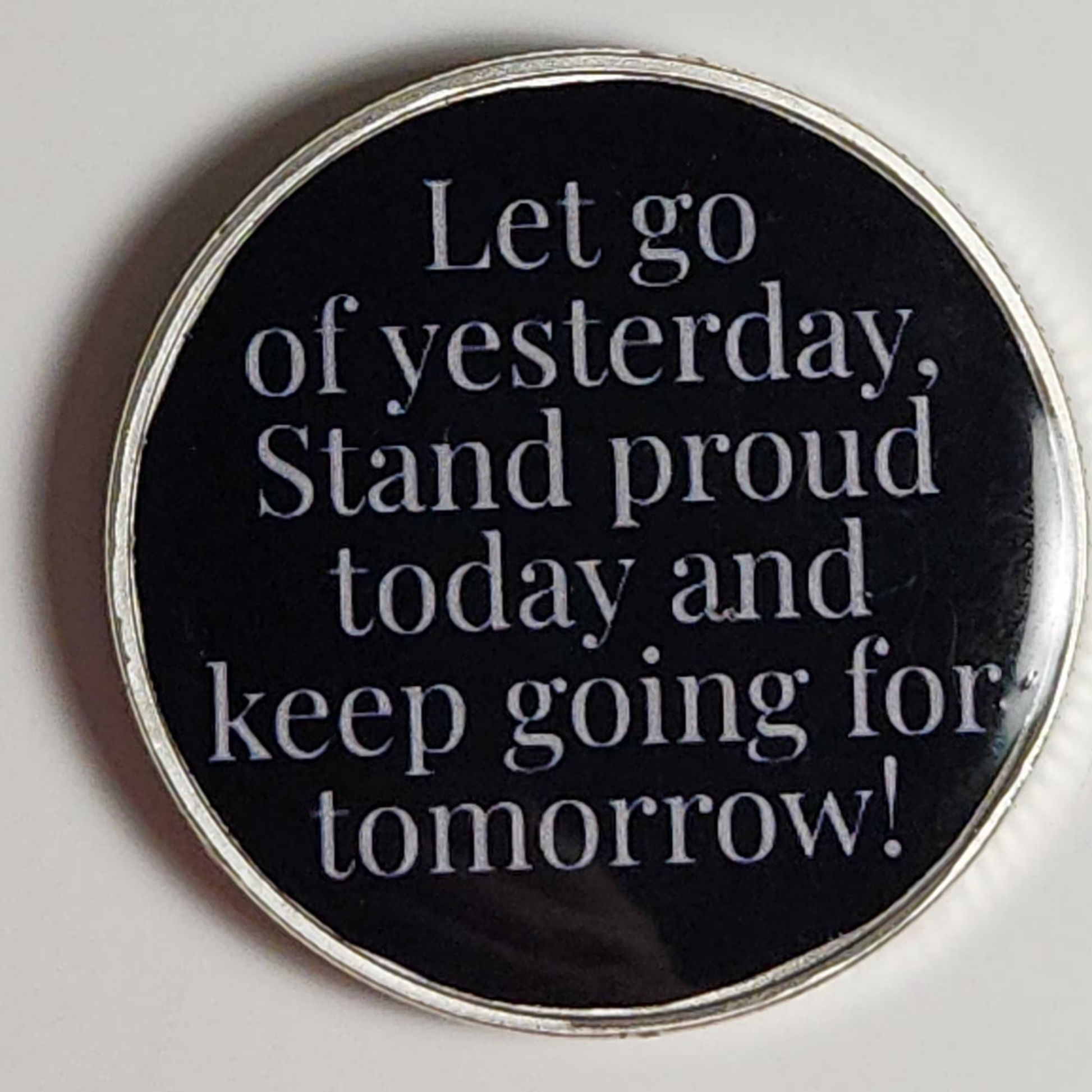 Black personalized coin with silver rim: Let go of yesterday, stand proud, keep going!