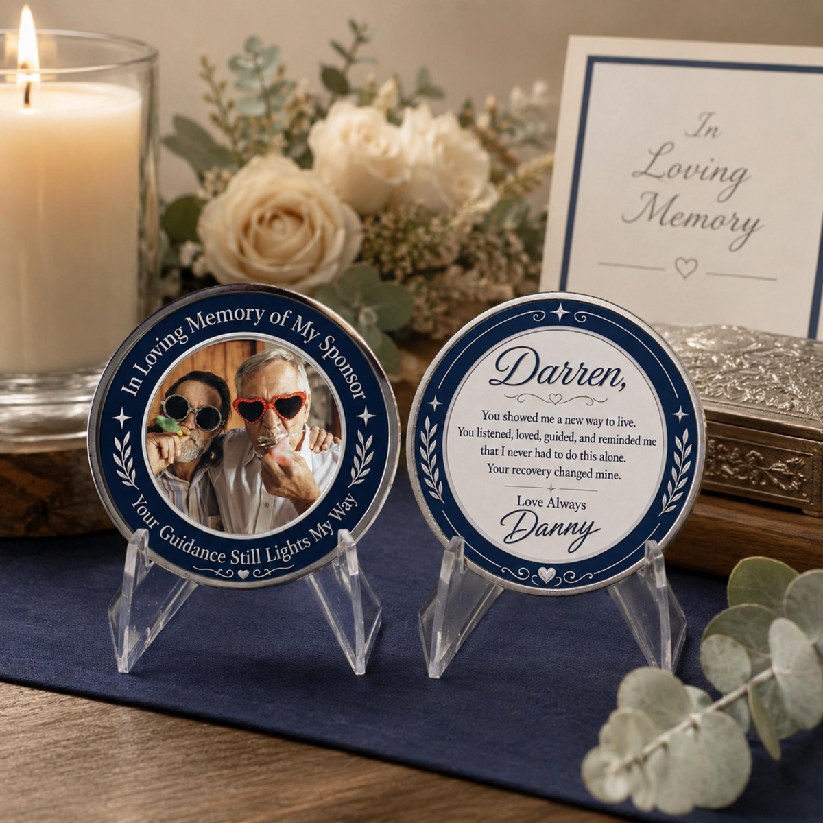 Blue memorial sponsor coins with two-photo portraits on clear stands on a table