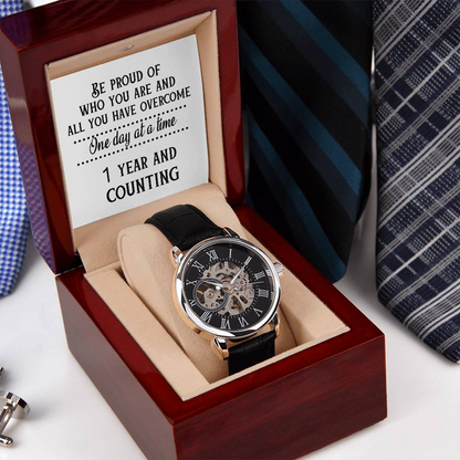 Skeleton dial openwork watch with black leather strap in burgundy open box cushion.