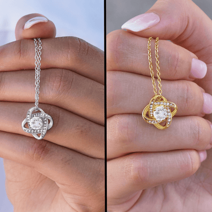 Heart-shaped rhinestone heart necklace on silver and gold chains, held in hand