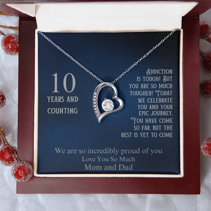 Heart pendant necklace with silver-tone chain on blue gift card in maroon box