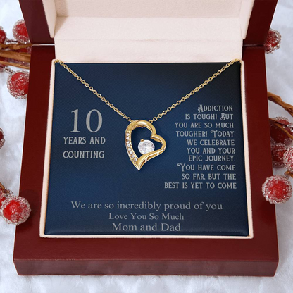 Gold heart pendant necklace in open gift box on blue card, with 10 years date 10/23/2014