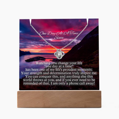 Heart-shaped rhinestone pendant necklace on chain over printed scenic keepsake card