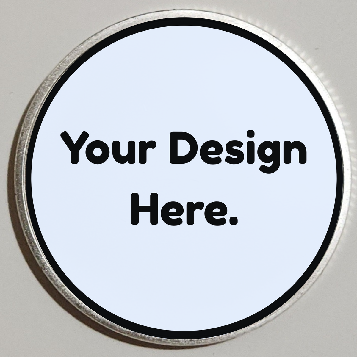 Round silver custom coin with placeholder text "Your Design Here" on light blue insert.