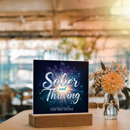 LED acrylic plaque with 'Sober and Thriving' and date on wood base