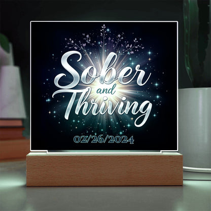 LED acrylic plaque with 'Sober and Thriving' and date on wood base, glowing lettering