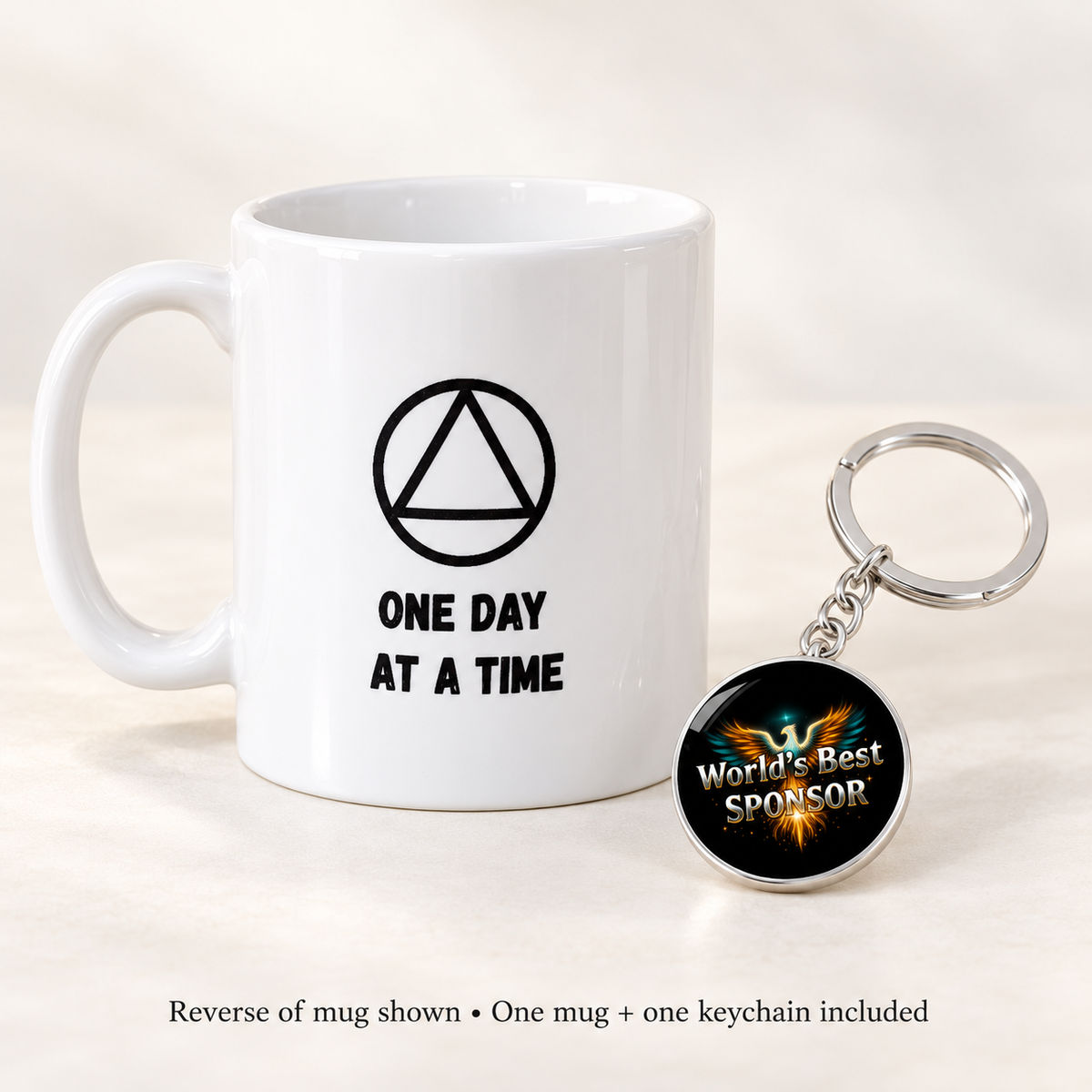 Reverse of the white mug shows a triangle symbol and “One Day at a Time,” with Phoenix keychain.