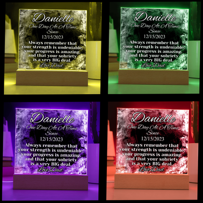 Colorful glowing LED acrylic name plaque on wood base, Danielle text