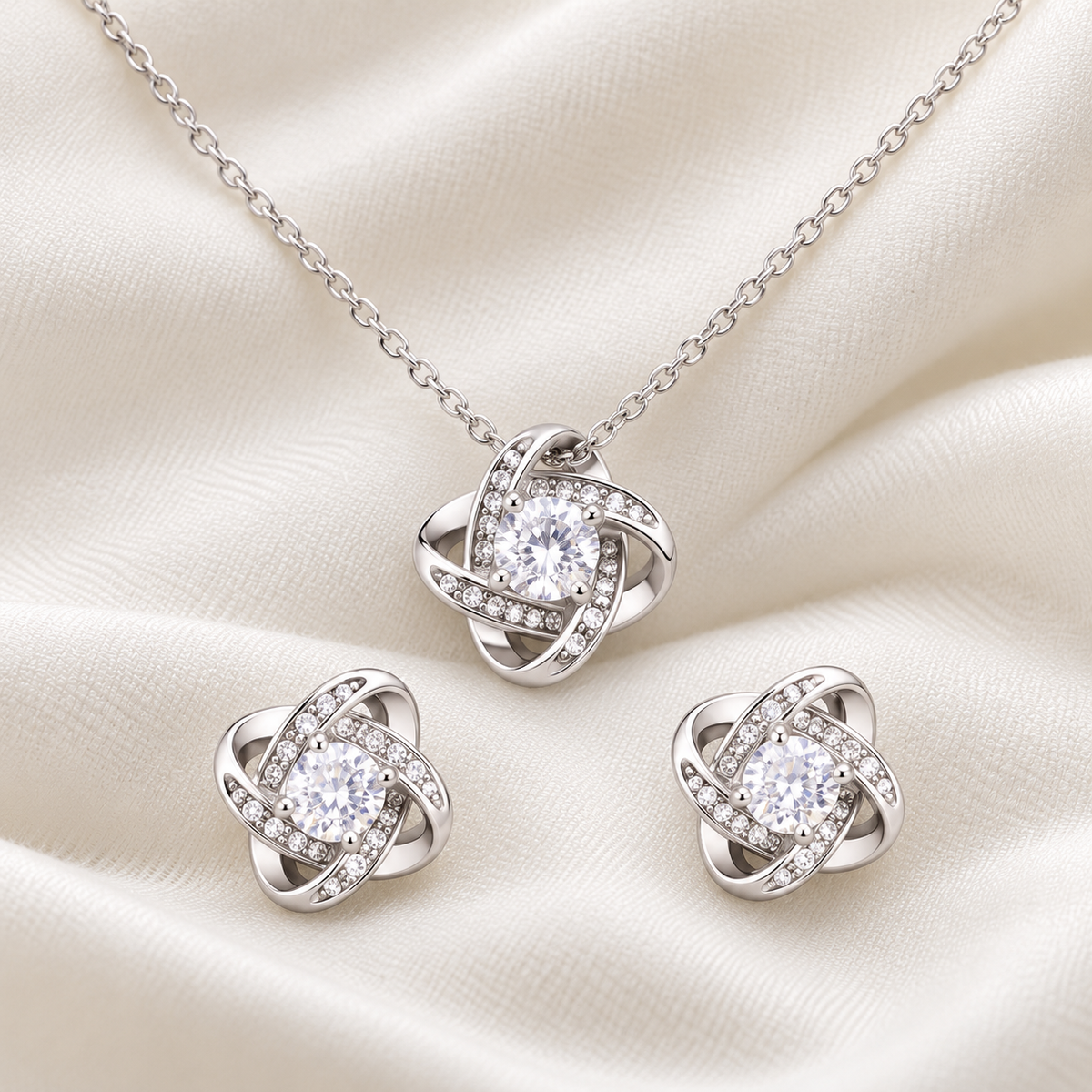 Close-up of a silver-tone crystal pendant necklace and matching stud earrings