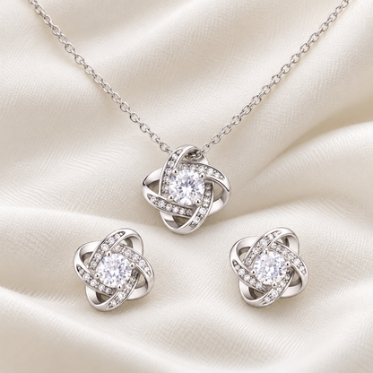 Close-up of a silver-tone crystal pendant necklace and matching stud earrings