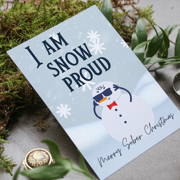 Light blue Christmas greeting card with snowman, snowflakes, and 'I AM SNOW PROUD' text