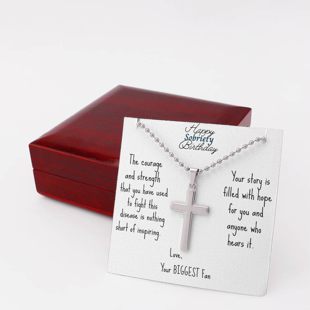 Silver cross necklace on engraved card inside a red jewelry box