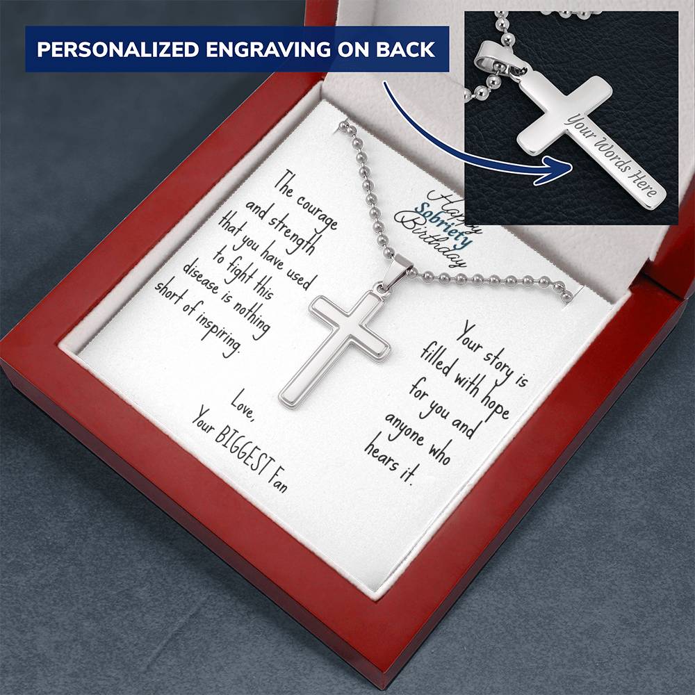 Silver cross necklace resting on engraved message card in red gift box