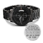 Black chronograph-style wristwatch with metal link band and round black dial