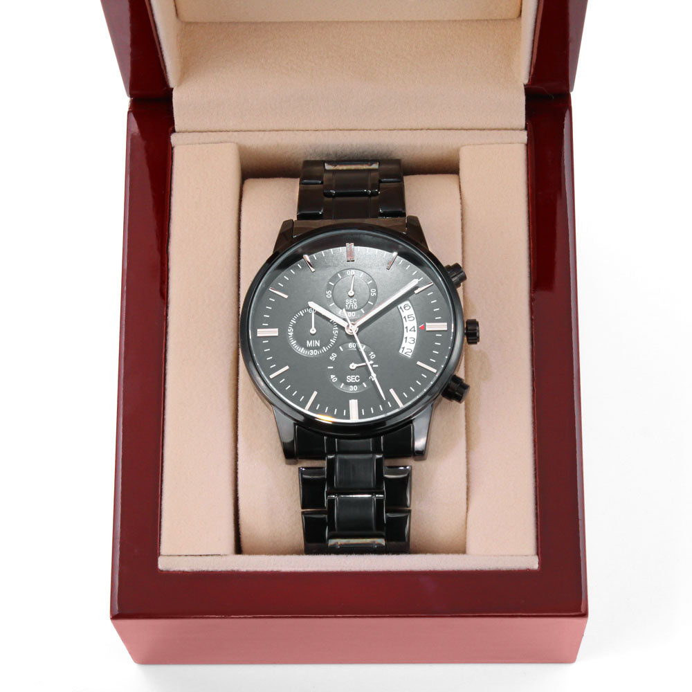 Black wristwatch in open box with beige insert and black metal bracelet