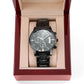 Black wristwatch in open box with beige insert and black metal bracelet