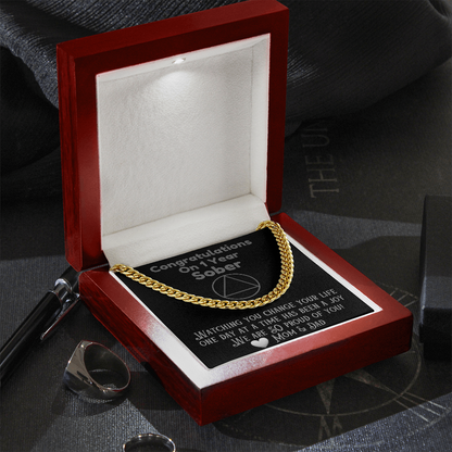 Gold Cuban link chain necklace resting in open gift box