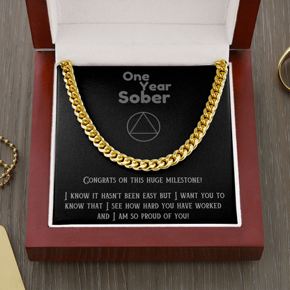 Gold Cuban link chain necklace on black gift card in open box