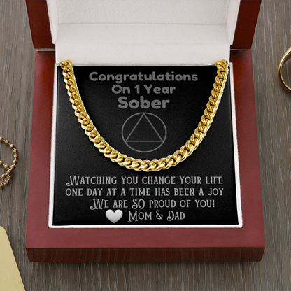 Gold Cuban link chain necklace displayed in open gift box, with clasp ends