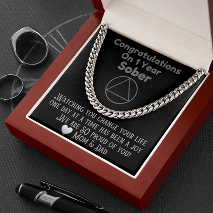 Silver Cuban link chain necklace laid across black insert in gift box