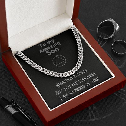 Stainless steel cuban link chain necklace resting on message card in red box