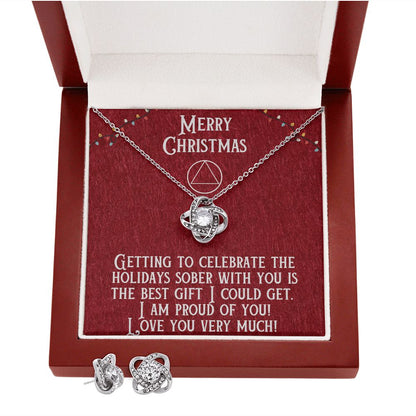Open gift box showing heart pendant necklace and stud earrings on red lining