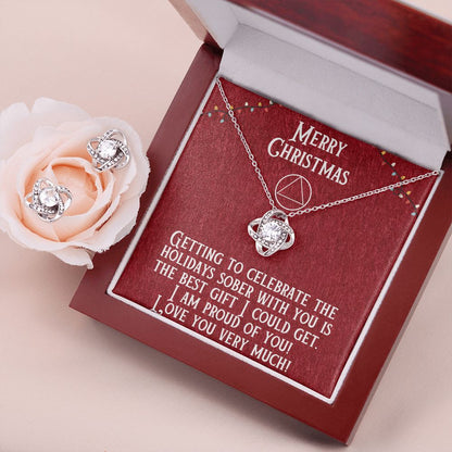 Heart pendant necklace and stud earrings set inside red gift box on tabletop