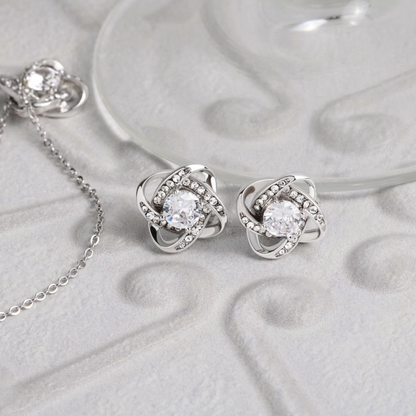 Silver-tone cubic zirconia knot stud earrings, round center stone with halo detail