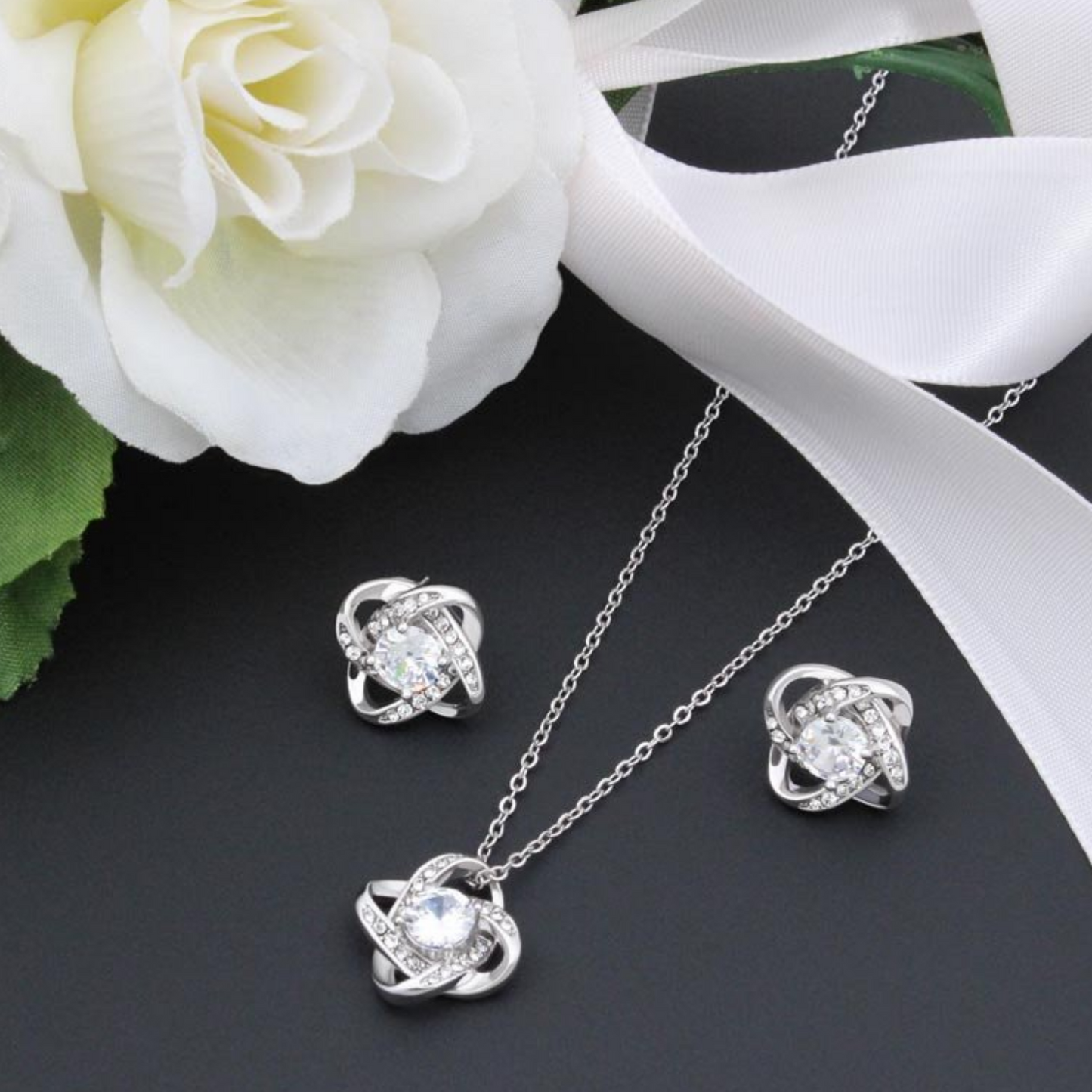 Cubic zirconia knot stud earrings in silver tone, round center with halo stones